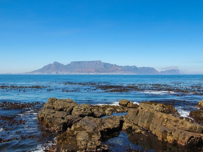 Uitzicht op de Tafelberg bij Kaapstad vanaf de rotskust aan zee tijdens de Route Zuid-Afrika.