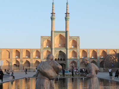 Amir Chakhmaq-complex in Yazd met twee minaretten en standbeelden bij de vijver.
