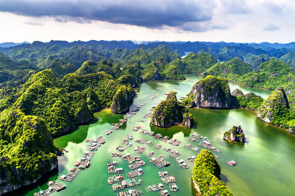 Groene kalkstenen eilanden en drijvende vissersdorpen in Halong Bay, Vietnam, tijdens een 22-35ers reis.