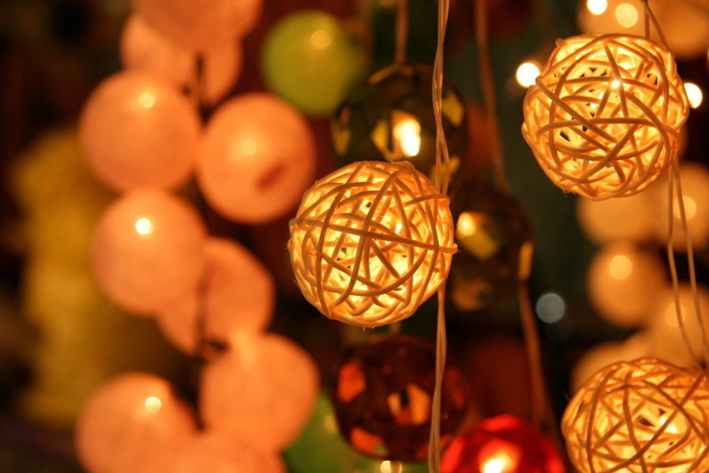 Sfeervolle lichtslingers met rieten lampionnen op een avondmarkt in Thailand tijdens een groepsrondreis.