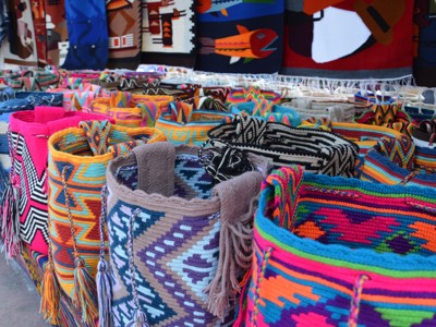 Kleurrijke handgeweven tassen en textiel op een markt in Ecuador tijdens de Route Ecuador en Galapagos.