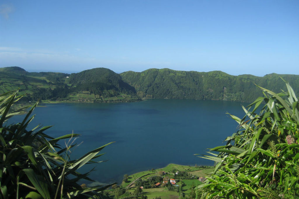 Uitzicht op een kratermeer met groene heuvels op São Miguel, Azoren, tijdens een wandelvakantie.