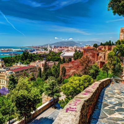 Uitzicht vanaf het Alcazaba in Málaga over de stad, haven en kustlijn tijdens een fietstocht in Andalusië.