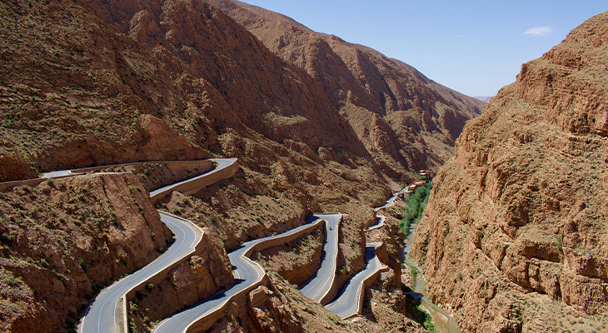 Dadeskloof Slingerweg door een bergkloof met rivier tussen rotsachtige heuvels.