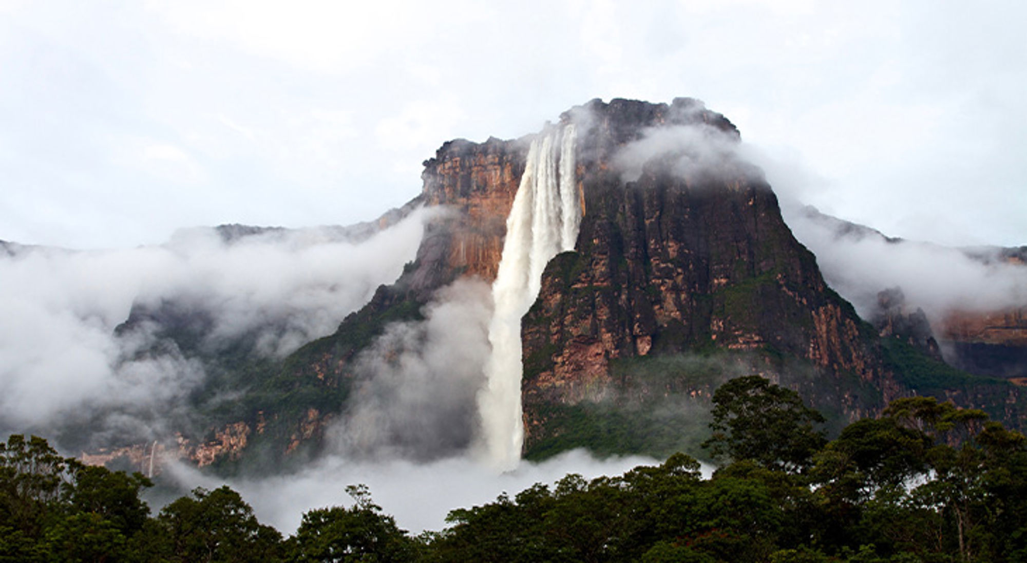 Angel Falls Kukenan-waterval die van een tafelberg stroomt, omringd door mist en groen regenwoud.