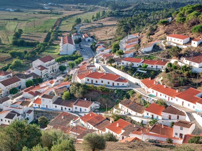 Uitzicht op een Portugees dorp met witgekalkte huizen en rode daken in de heuvels van Alentejo en Algarve.