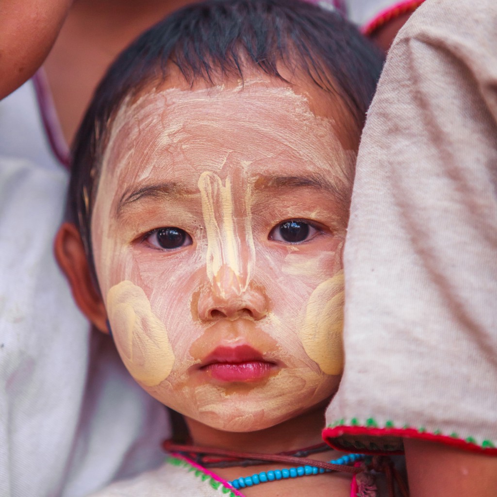 Portret van een kind in Myanmar met thanaka op het gezicht tijdens de groepsrondreis Myanmar Hoogtepunten.