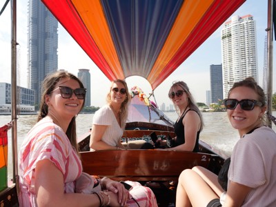 Vrienden varen met een longtailboot over de rivier in Bangkok tijdens de route Thailand.