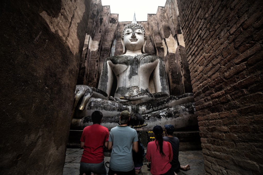 Gezin bij grote zittende Boeddha in tempelruïne in Thailand tijdens Familiereis Thailand Comfort-Plus.