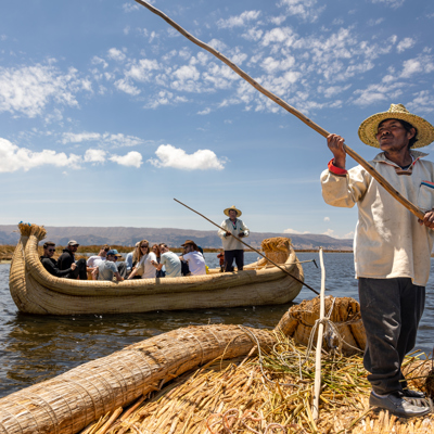 Reizigers varen op een rieten boot op het Titicacameer tijdens een 22-35ers groepsrondreis Peru.