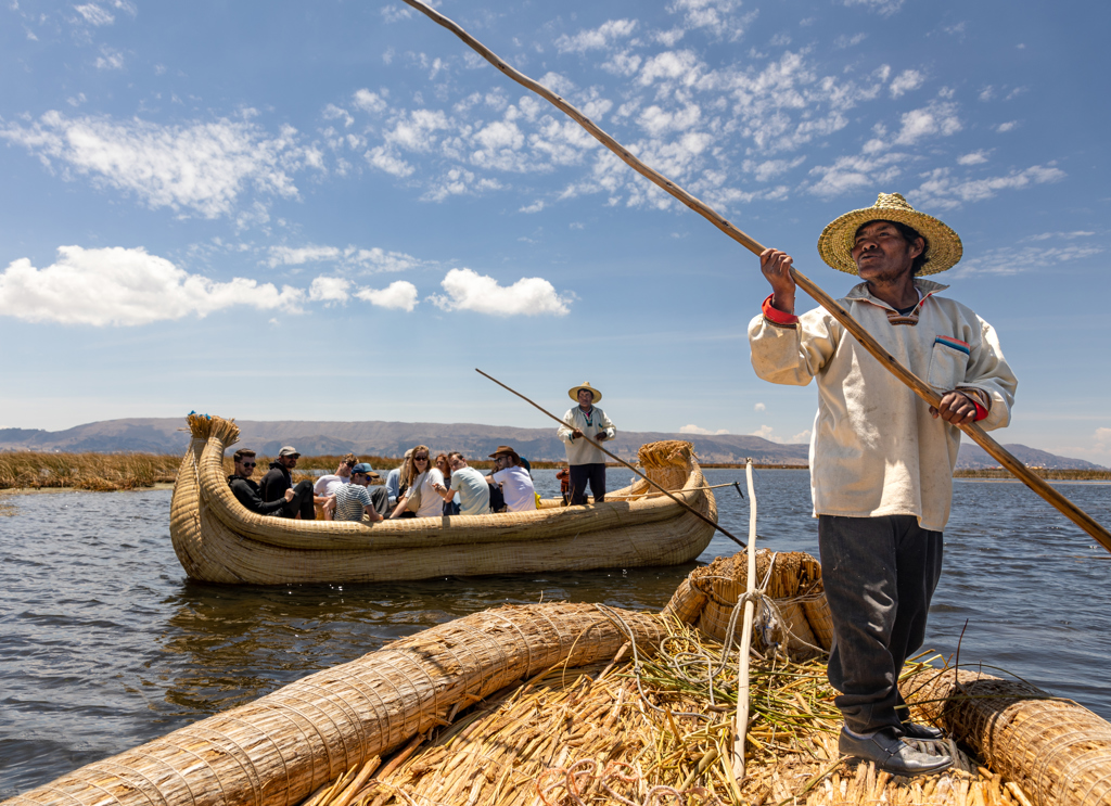 Reizigers varen op een rieten boot op het Titicacameer tijdens een 22-35ers groepsrondreis Peru.