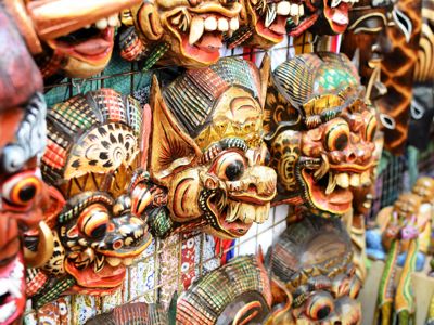 Kleurrijke Balinese houtsnijmaskers op een markt in Bali tijdens de Route Bali, 18 dagen.