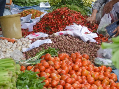 Groentemarkt op Sumatra met tomaten, rode pepers, knoflook en sjalotten op kramen.
