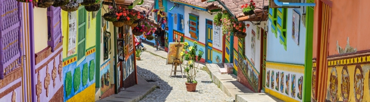 Kleurrijke straat met beschilderde huizen en hangende bloemen in Guatapé, Colombia.