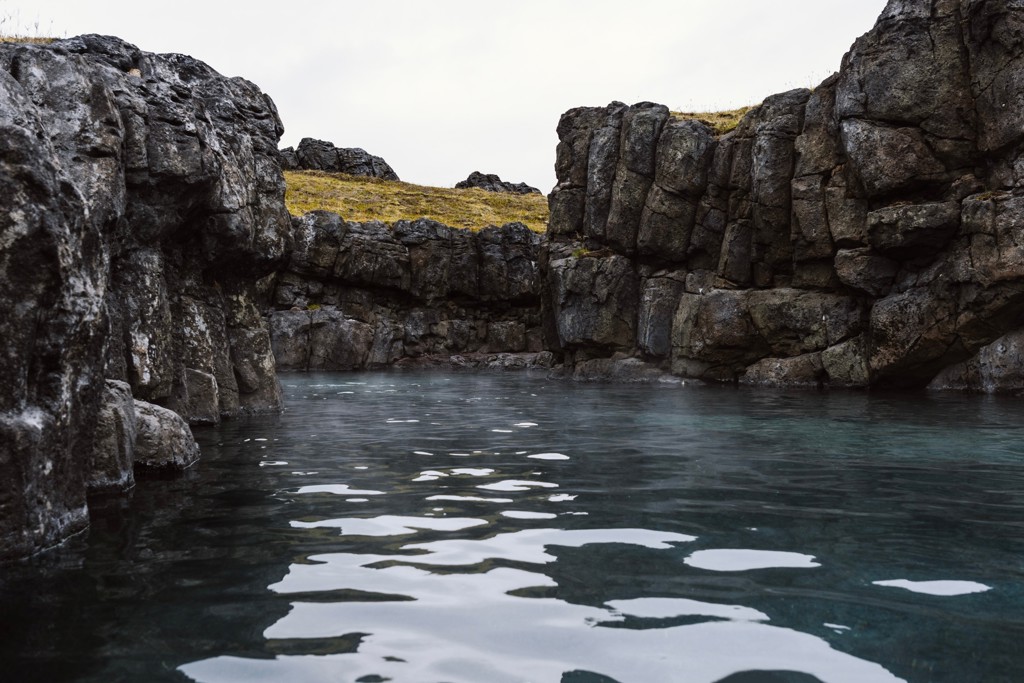 Warmwaterbron tussen lavastenen in IJsland tijdens groepsrondreis in de winter.