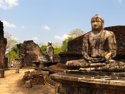 Zittend Boeddhabeeld tussen ruïnes van de oude stad Polonnaruwa op de route Sri Lanka.