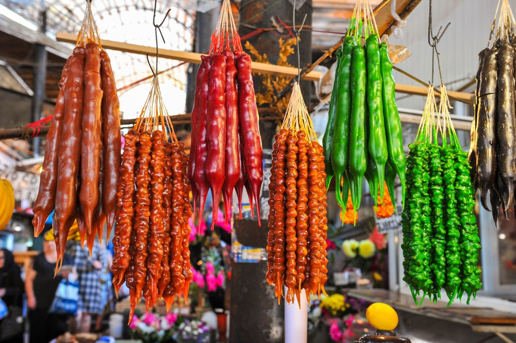 Gekleurde churchkhela (walnoot- en druivensnoep) op een markt tijdens groepsrondreis Armenië en Georgië.