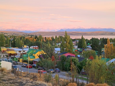 Uitzicht op El Calafate met kleurrijke huizen, Lago Argentino en besneeuwde Andes op de achtergrond.