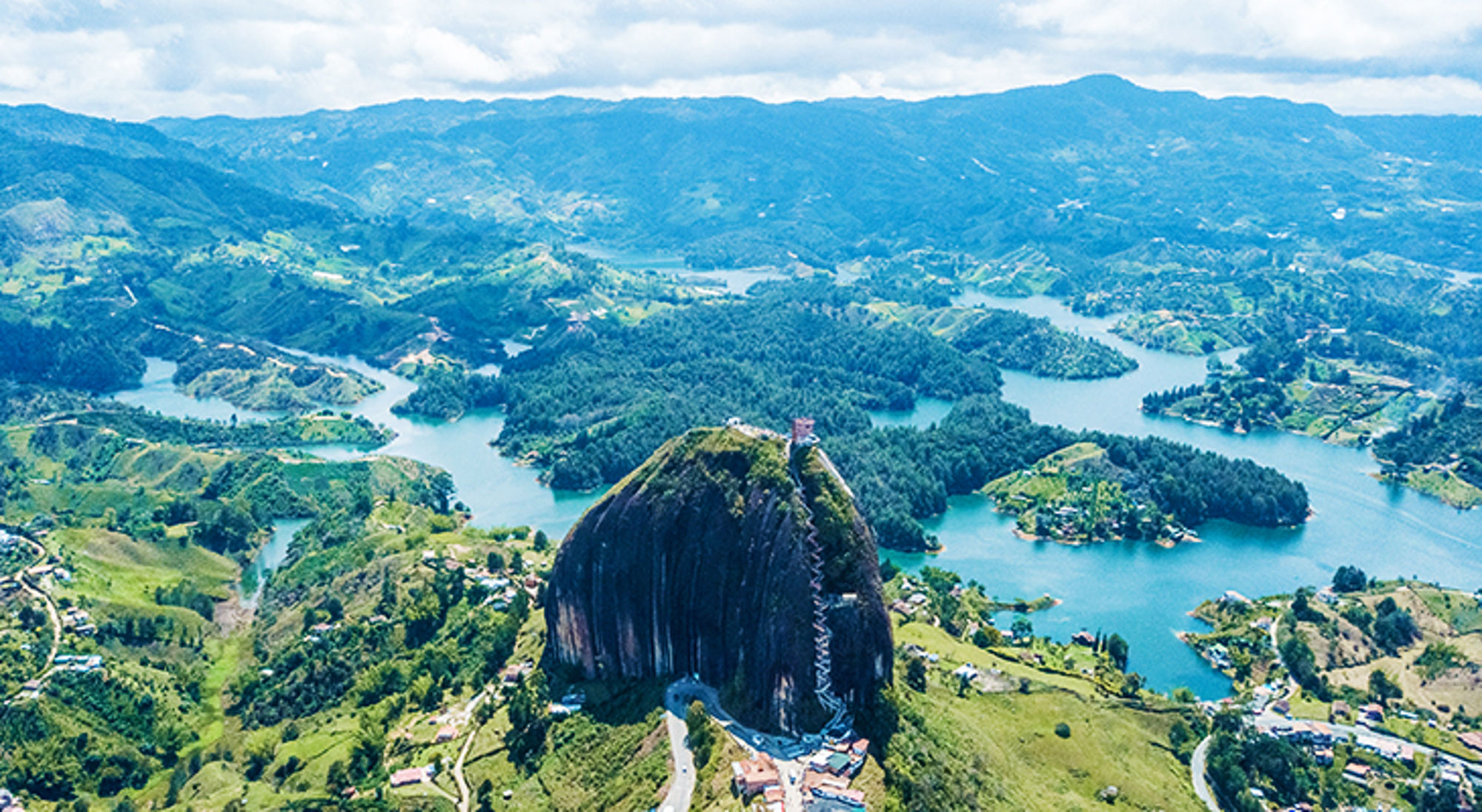 Uitzicht op El Peñón de Guatapé met trappenpad en het stuwmeer met groene eilanden in Colombia.