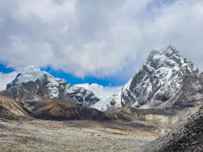 Besneeuwde bergtoppen en gletsjerlandschap langs de Route Nepal Everest Base Camp onder een deels bewolkte lucht.
