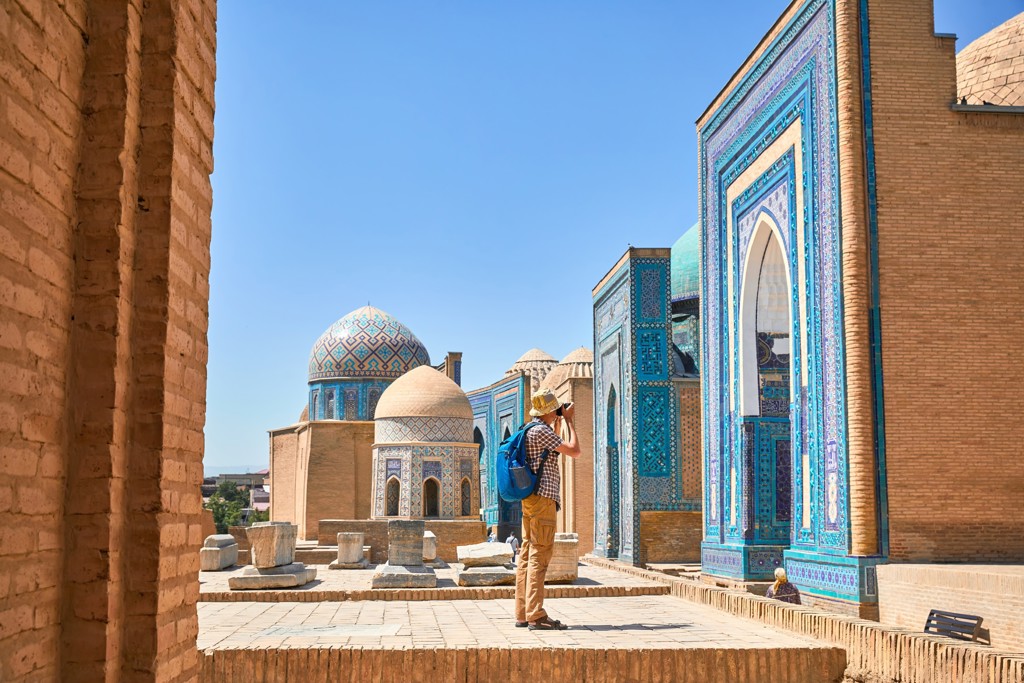 Bezoeker fotografeert blauw betegelde moskee en koepels in Samarkand tijdens groepsrondreis Oezbekistan.