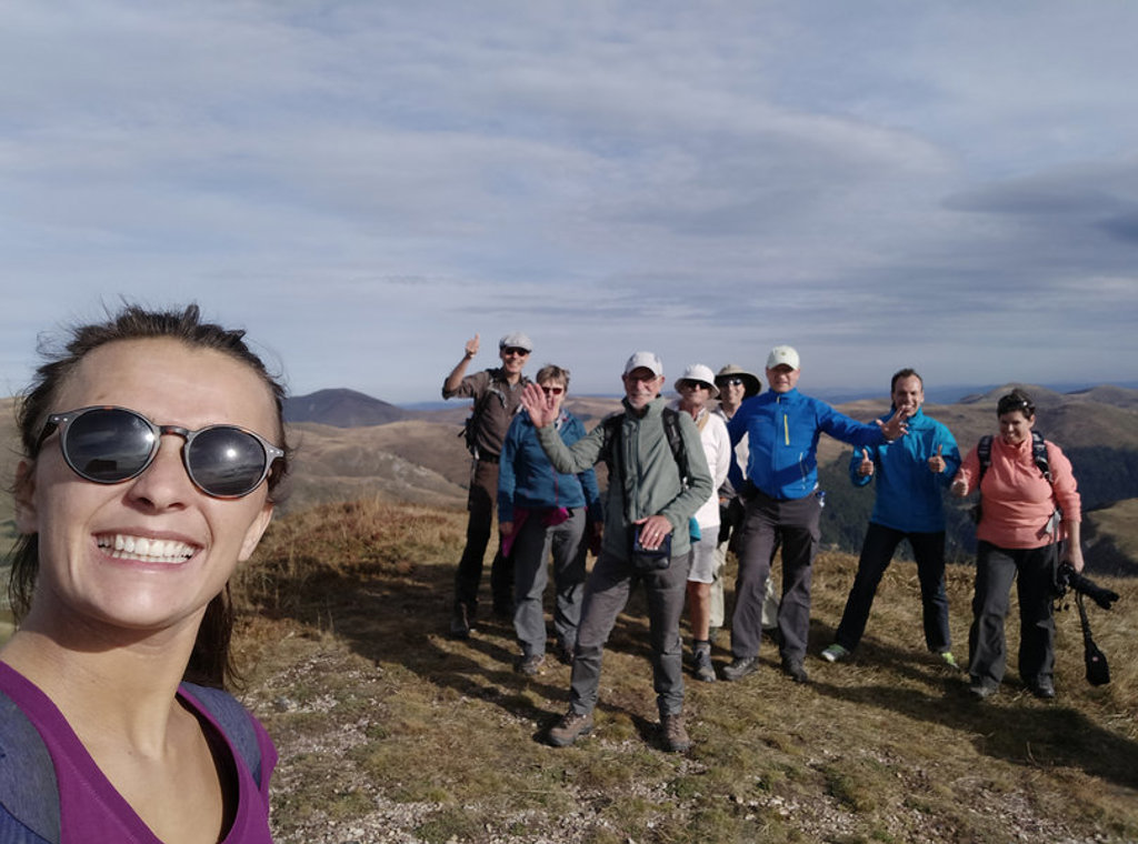 Groep wandelaars op bergtop met uitzicht over het landschap tijdens wandelvakantie in Montenegro.