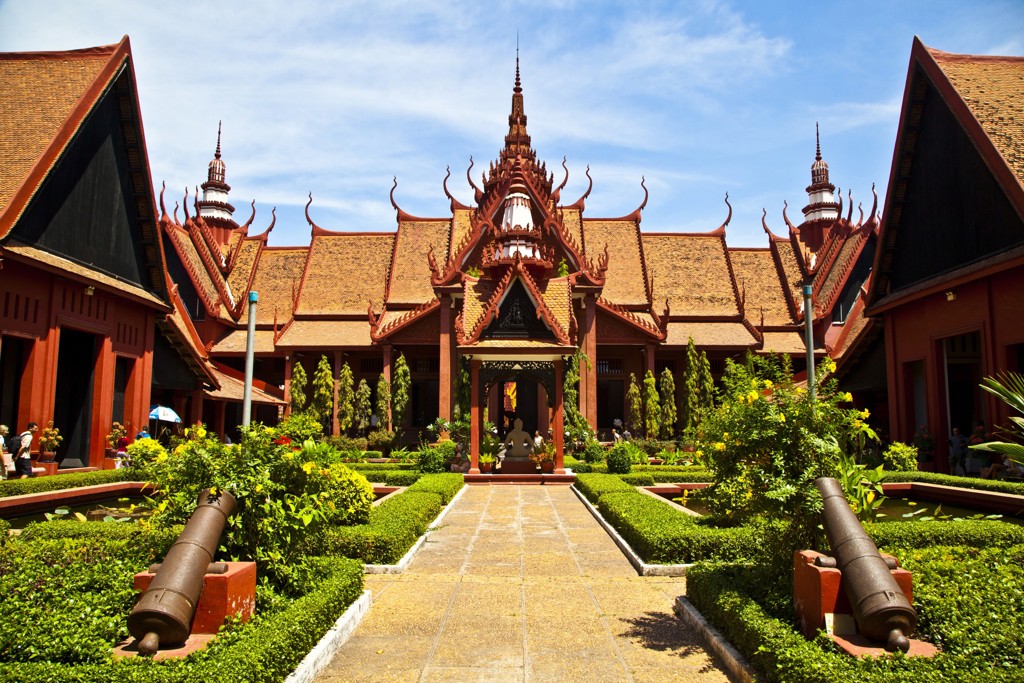 Binnenplaats van het Koninklijk Paleis in Phnom Penh, Cambodja, met sierlijke tempeldaken en tuinpad.