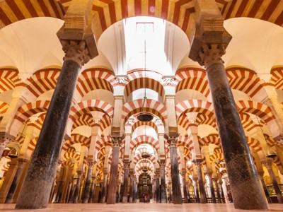 Interieur van de Mezquita van Córdoba met rood-wit gestreepte bogen en zuilen.