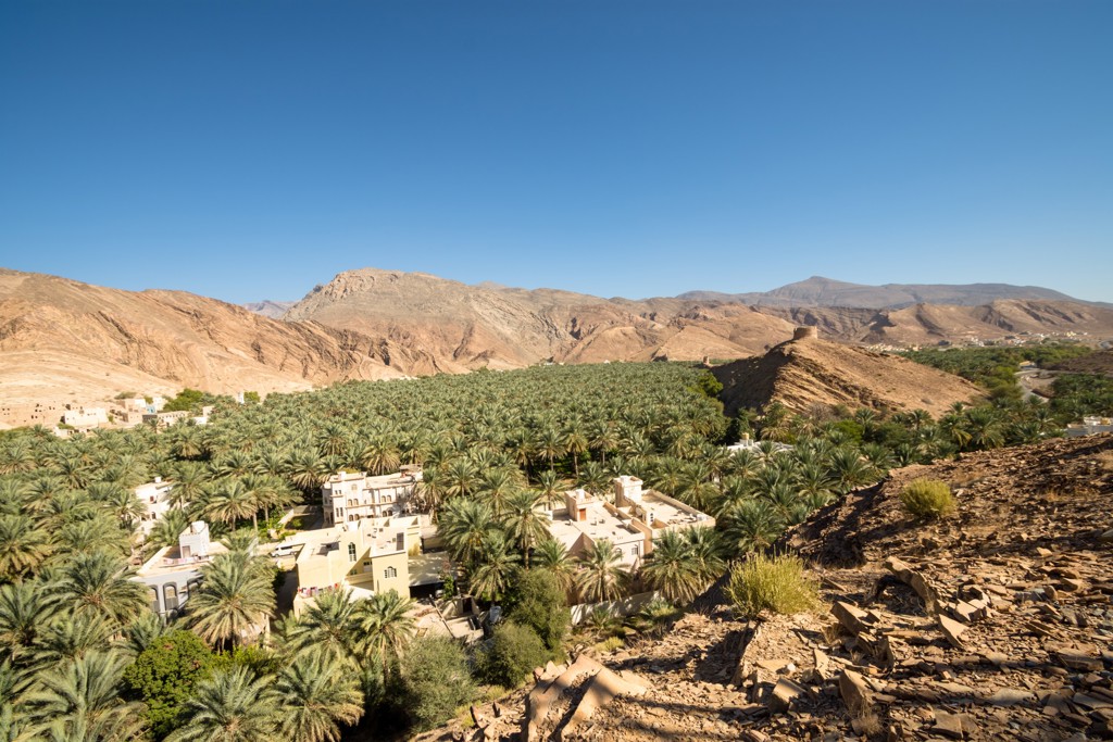 Palmoase met dorp en bergen in Oman, onderdeel van de groepsrondreis Oman en Dubai.