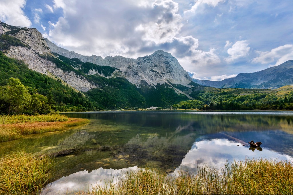 Bergmeer met spiegeling van ruige bergtoppen en groene hellingen in Bosnië en Herzegovina.