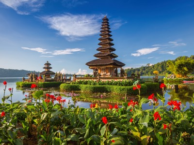 Pura Ulun Danu Bratan tempel aan het Bratanmeer op Bali, met rode bloemen op de voorgrond.