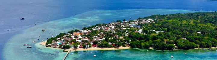 Bunaken met tropisch eiland, turquoise koraalrif en vulkaan op de achtergrond.