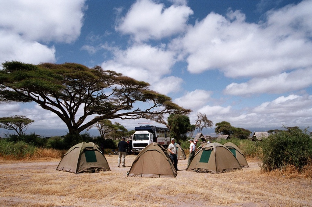 Kampeerplek met safaritenten en reisbus tijdens groepsrondreis Kenia, Tanzania en Zanzibar.