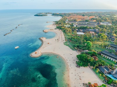 strand en kustlijn bij Nusa Dua op Bali, met resorts en turquoise zee.