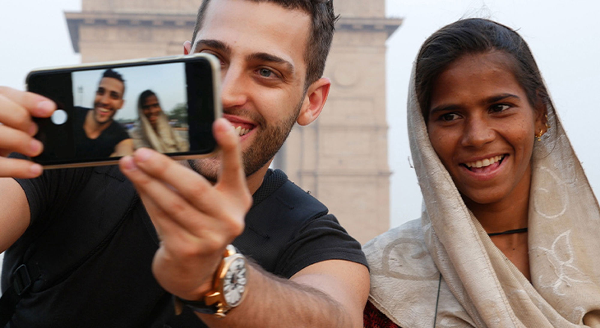 Leer een aantal basiswoorden van de lokale taal Toerist maakt selfie met lokale vrouw bij de India Gate in New Delhi.