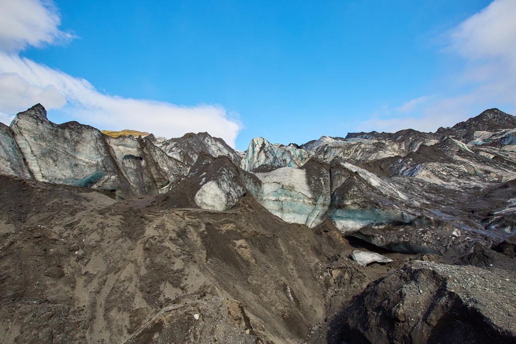 Gletsjerlandschap langs de Laugavegur Trail in IJsland, met ijsformaties en zwarte vulkanische rotsen.