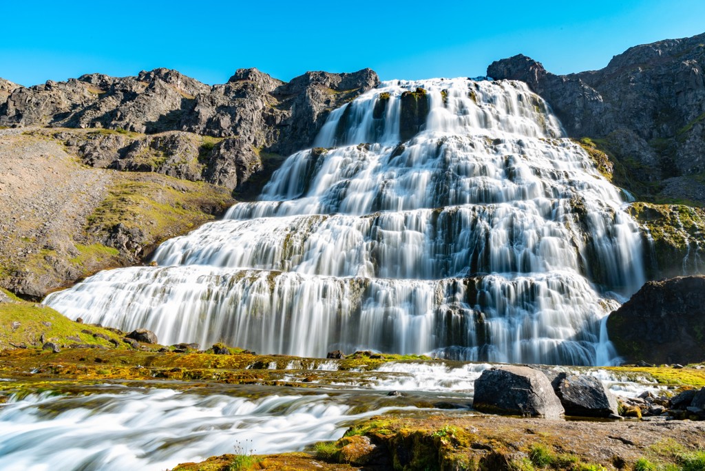 Brede waterval in rotsachtig landschap in IJsland tijdens groepsrondreis kamperen.
