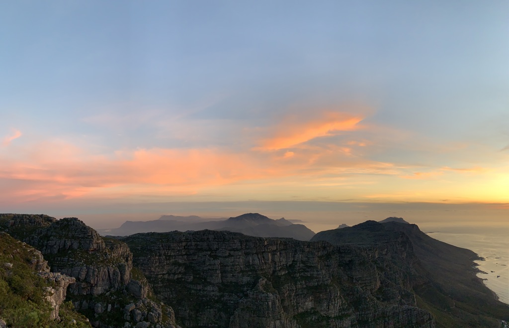 Zonsondergang boven de Tafelberg en de kust bij Kaapstad tijdens een 22-35ers reis Zuid-Afrika.