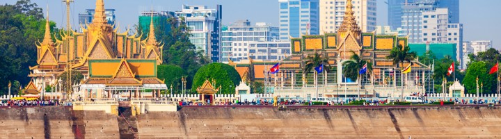Koninklijk Paleis van Phnom Penh aan de oever van de Tonlé Sap-rivier, met skyline op de achtergrond.