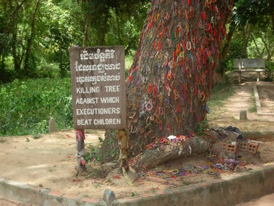 Killing Tree in Choeung Ek, Cambodja, met herdenkingsarmbandjes en informatiebord.