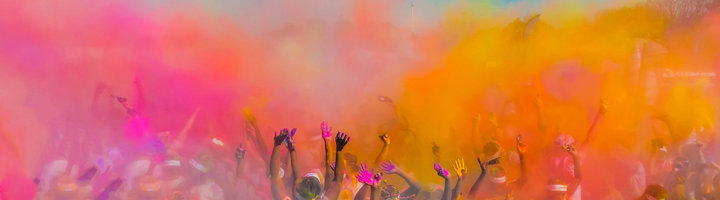 Festivalgangers vieren in een wolk van kleurrijk poeder tijdens een festivalreis.