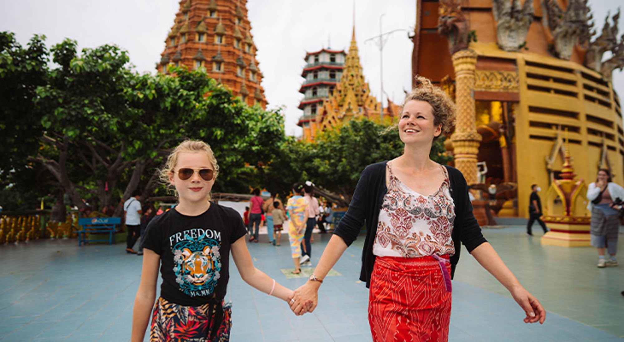 Moeder en dochter wandelen hand in hand bij de Tiger Cave Temple in Krabi, Thailand.