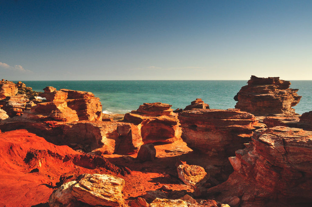 Rode rotsformaties aan de kust van West-Australië met uitzicht op de oceaan.