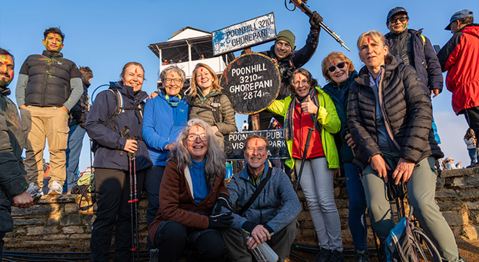 Poon Hill Groep wandelaars poseert bij het Poon Hill-bord (3210 m) tijdens een trekking in Nepal.
