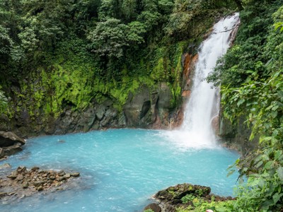 Waterval in het groene regenwoud van Costa Rica met helderblauw water in een natuurlijke lagune.