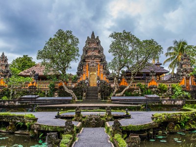 Traditionele Balinese tempelpoort met vijver en weelderige tuin, tijdens de Route Java en Bali.