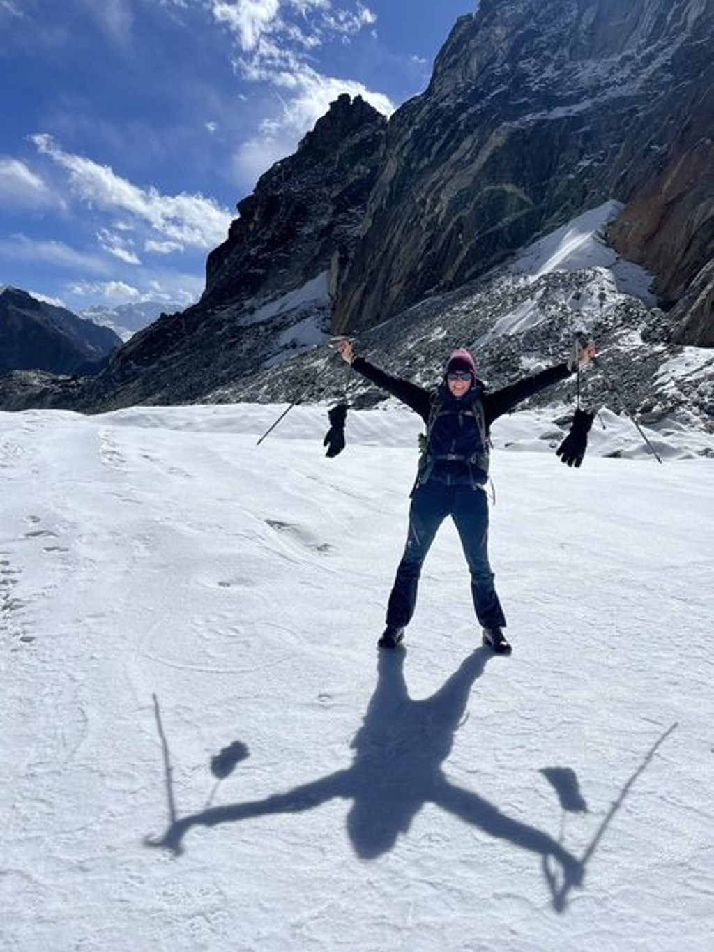 Trekker met gespreide armen bij rotswand tijdens groepsrondreis Nepal Everest.