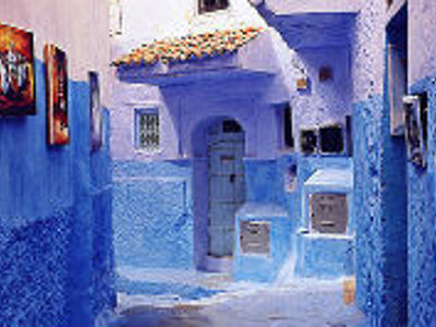 Blauwgeschilderde straat met witblauwe huizen en trappen in Chefchaouen, Marokko.