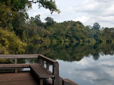 Houten uitkijkplatform aan een rustig meer met jungleheuvels op de Route Cambodja en Thailand, 21 dagen.