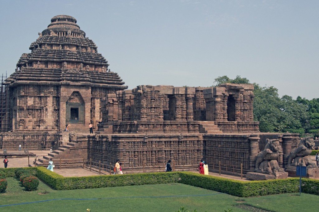 Zonnetempel van Konark in Orissa, India, met rijk versierde stenen muren en bezoekers op het tempelterrein.